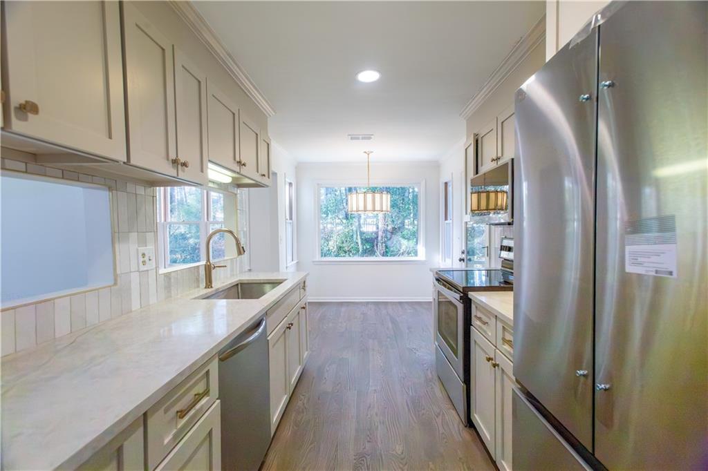 45 St Claire Lane Northeast Atlanta, GA 30324 - Photo 16 of 29 a kitchen with granite countertop a sink a counter space and stainless steel appliances