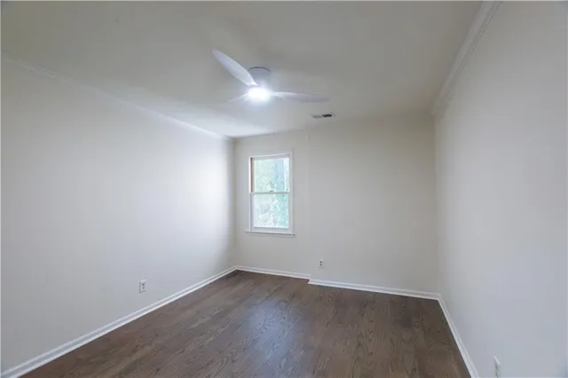 an empty room with wooden floor and window