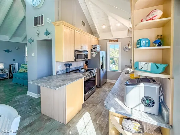 a kitchen that has a stove and a wooden floor