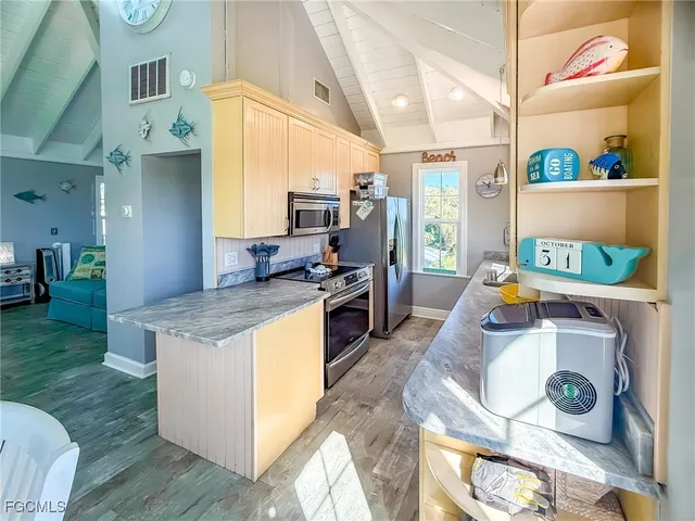 a kitchen that has a stove and a wooden floor