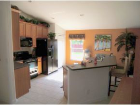 1010 Northeast Morgan Palm Bay, FL 32905 - Photo 4 of 12 a kitchen with kitchen island a sink appliances and cabinets
