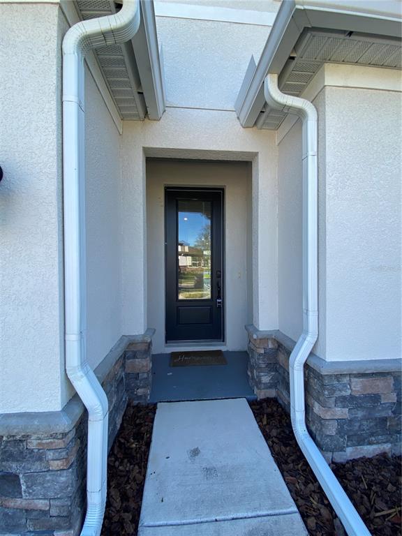 34273 Radley Way Wesley Chapel, FL 33545 - Photo 2 of 38 a hallway with white doors wooden floor and stairs