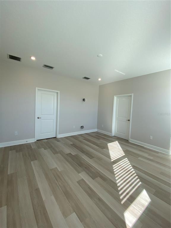 34273 Radley Way Wesley Chapel, FL 33545 - Photo 22 of 38 a view of a room with wooden floor and white walls