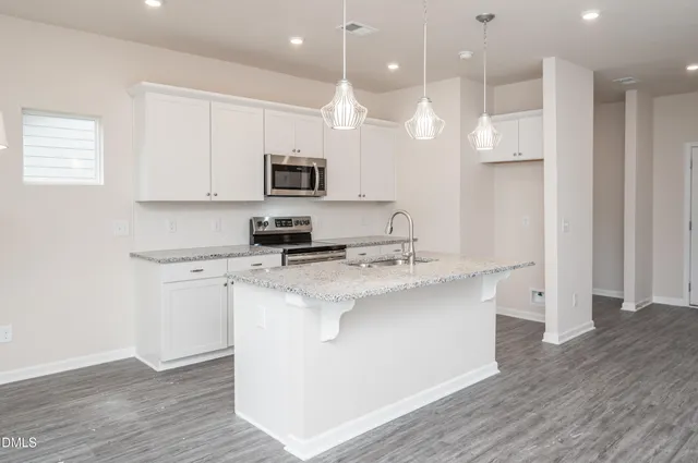 a kitchen with kitchen island a sink stainless steel appliances and cabinets