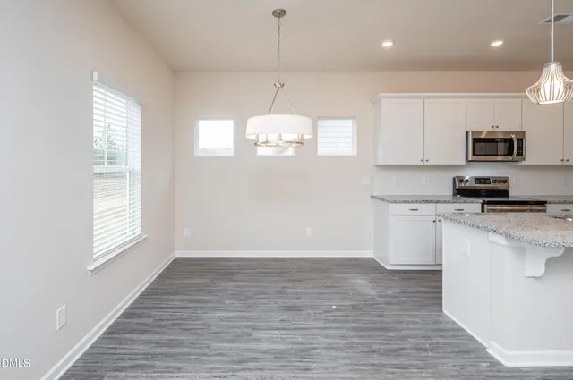 a kitchen with granite countertop a stove a sink and a window