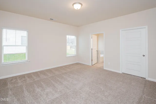 an empty room with windows and closet