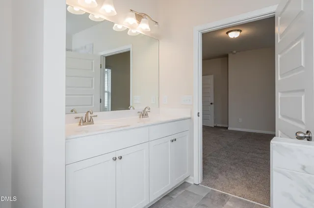 a bathroom with a double vanity sink and a mirror
