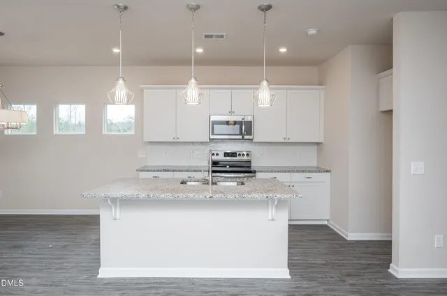 a kitchen with kitchen island a sink stainless steel appliances and cabinets