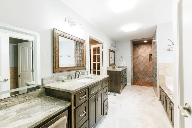 a bathroom with a granite countertop sink and a mirror