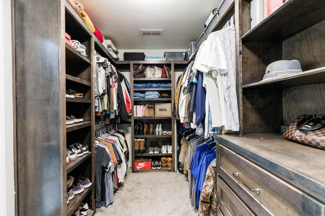 a view of walk in closet with empty racks