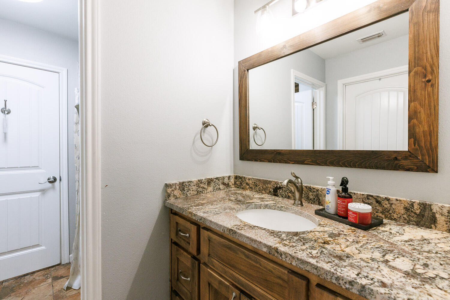 6523 East C R 6200 Lubbock, TX 79403 - Photo 58 of 86 a bathroom with a granite countertop sink and a mirror