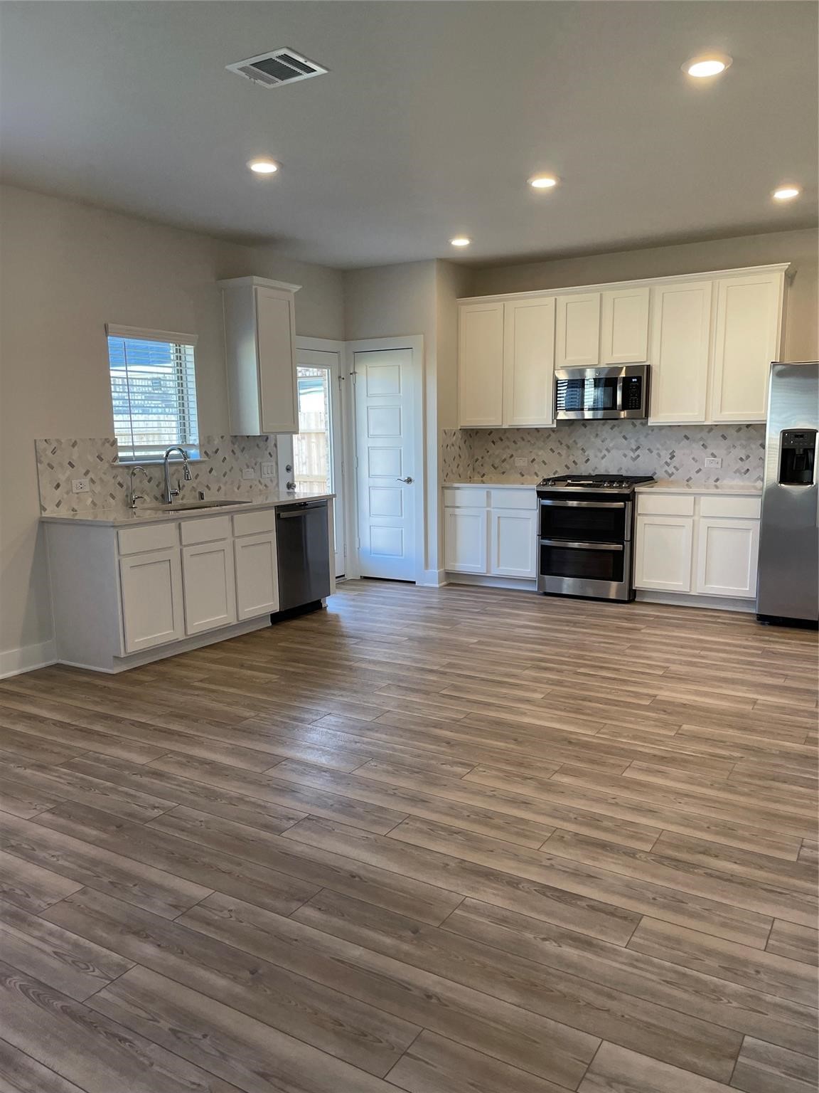 10638 Whitejacket Conroe, TX 77385 - Photo 12 of 25 a large kitchen with stainless steel appliances wooden floors and granite counter tops