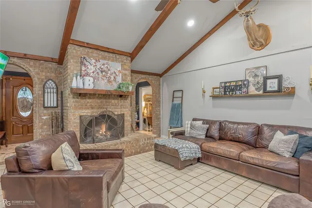 a living room with furniture a fireplace and a flat screen tv
