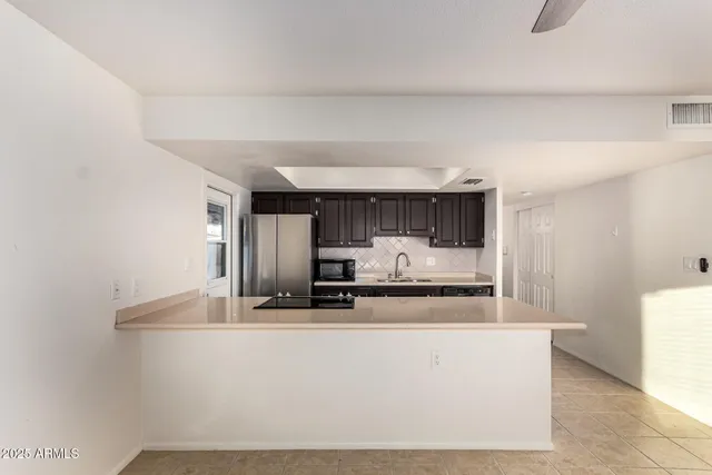 a kitchen with kitchen island a stove a sink and a refrigerator