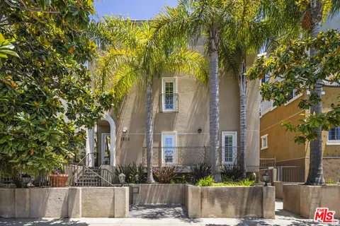 a front view of a house with plants