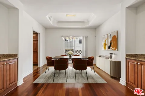 a view of a dining room with furniture a rug and wooden floor