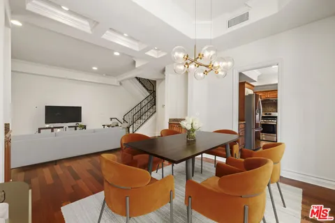 a living room with furniture a flat screen tv and a chandelier