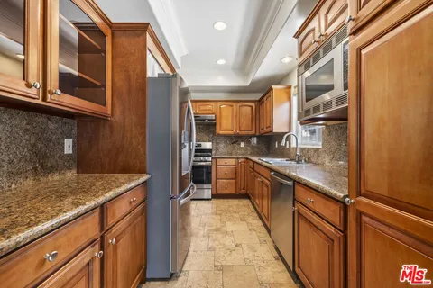 a kitchen with stainless steel appliances granite countertop a refrigerator and a sink