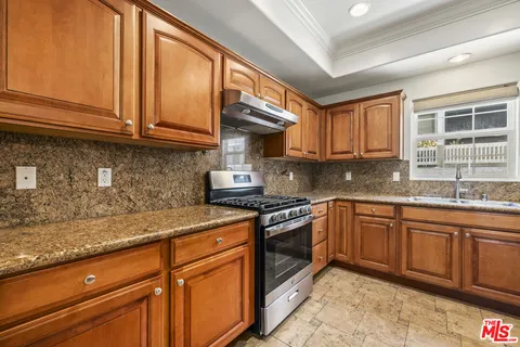 a kitchen with stainless steel appliances granite countertop a sink stove and cabinets