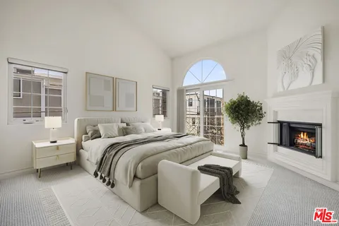 a spacious bedroom with a balcony a bed and a fireplace