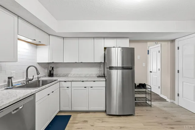 a kitchen with a refrigerator sink and cabinets