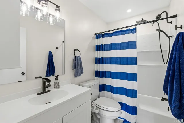 a bathroom with a sink a toilet a mirror and shower