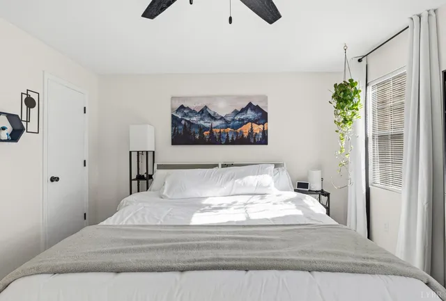 a bedroom with a large bed and a chandelier