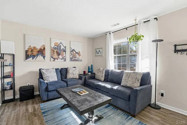 a living room with furniture and a window with wooden floor