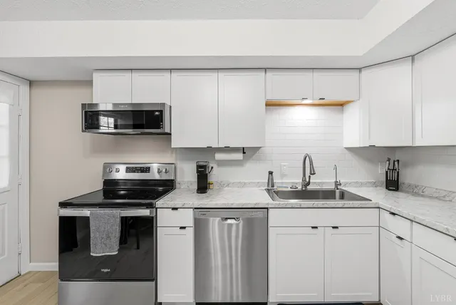 a kitchen with appliances a sink and cabinets