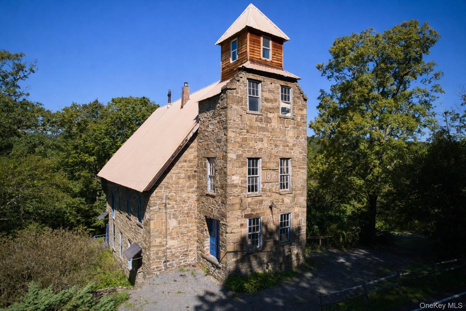 View of side of property featuring a metal roof and stone siding