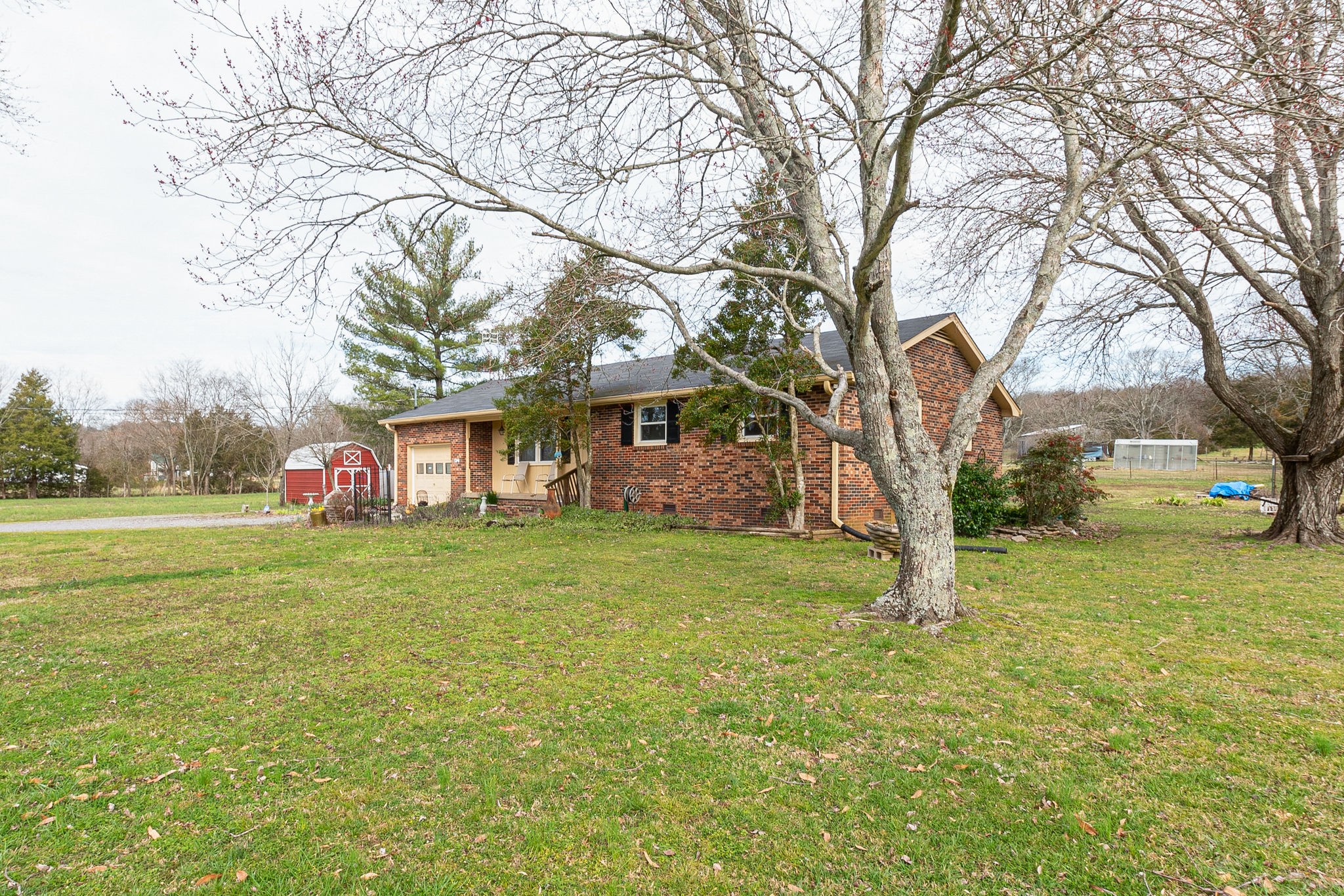 765 Lindsley Road Lebanon, TN 37090 - Photo 4 of 32 a front view of a house with a garden and trees