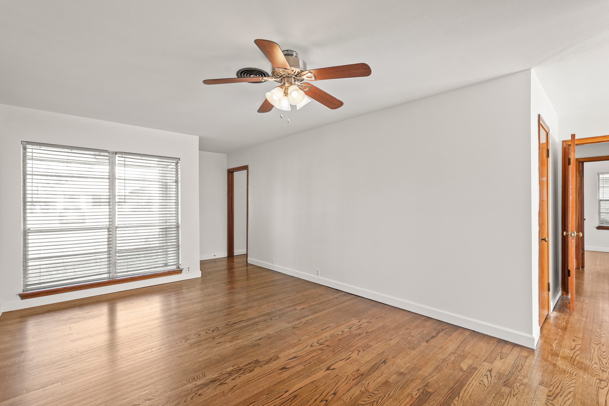 1207 Stonecrest Drive Houston, TX 77018 - Photo 10 of 34 an empty room with wooden floor fan and windows