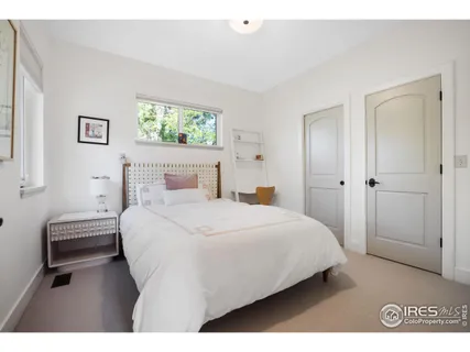 a bedroom with a bed and a painting on the wall