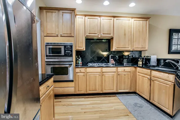 a kitchen with stainless steel appliances a refrigerator sink and cabinets