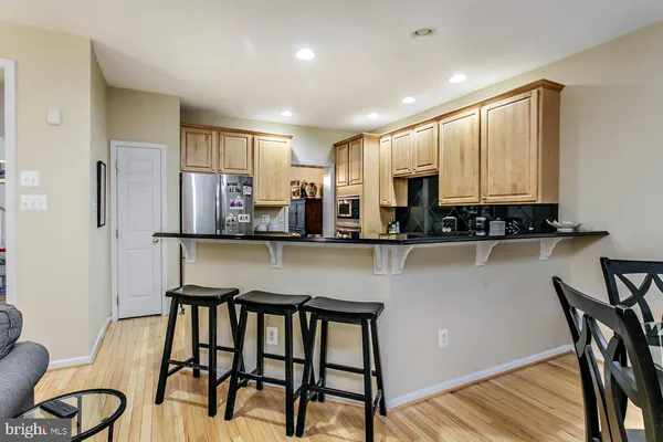 a kitchen with stainless steel appliances granite countertop table chairs sink and cabinets