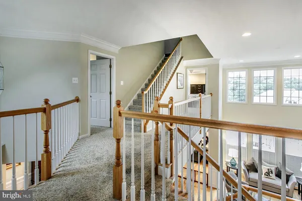 a view of staircase with lots of frames on wall and windows
