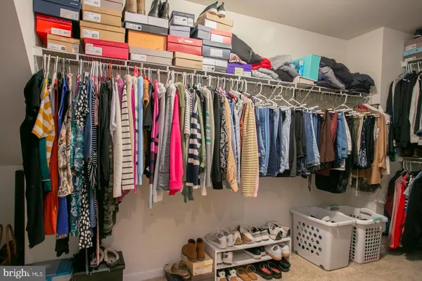 a view of walk in closet with clothes