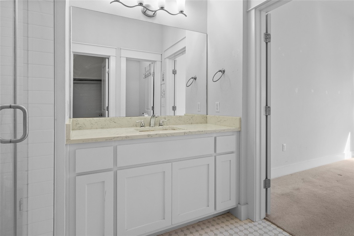 13001 Hymeadow Drive, Unit 31 Austin, TX 78729 - Photo 19 of 40 Bathroom featuring vanity, light colored carpet, a walk in closet, and light floors