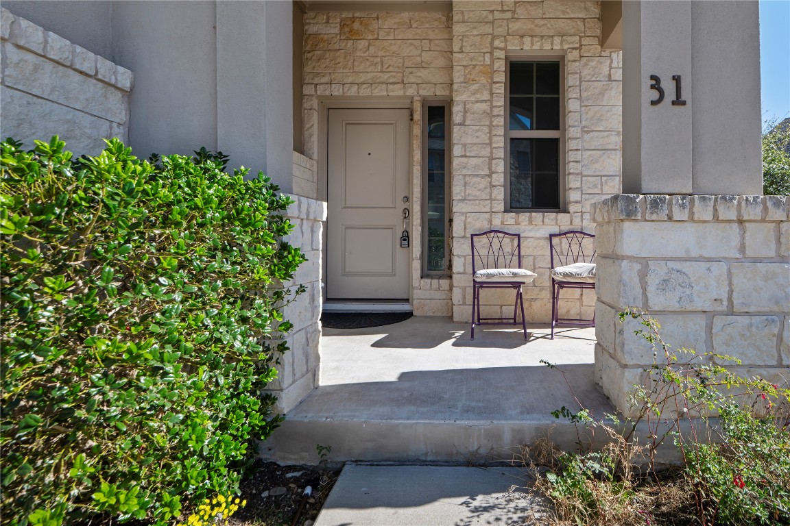 13001 Hymeadow Drive, Unit 31 Austin, TX 78729 - Photo 2 of 40 Doorway to property featuring stone siding and covered porch