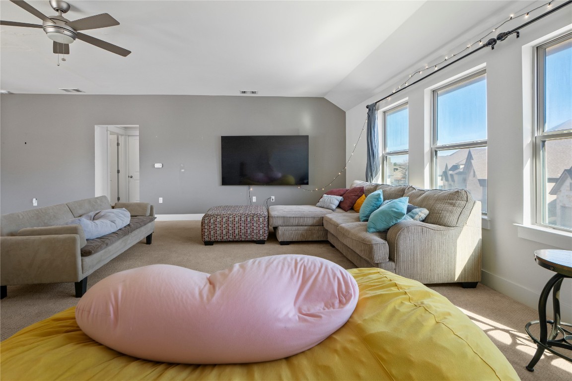 13001 Hymeadow Drive, Unit 31 Austin, TX 78729 - Photo 24 of 40 Living room featuring light colored carpet, vaulted ceiling, and ceiling fan