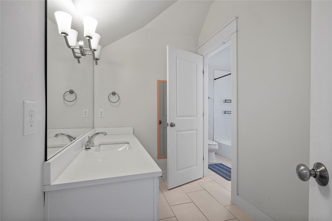 13001 Hymeadow Drive, Unit 31 Austin, TX 78729 - Photo 31 of 40 Bathroom with vanity, vaulted ceiling, a chandelier, bathing tub / shower combination, and light tile patterned floors