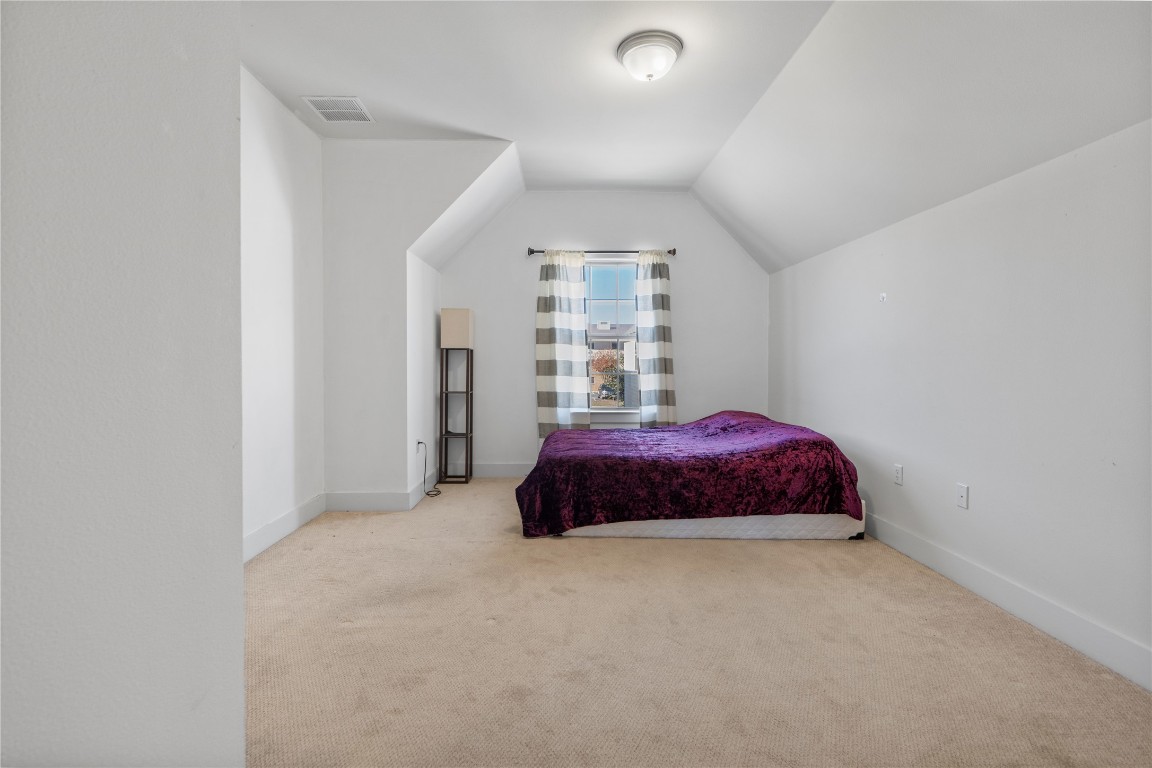 13001 Hymeadow Drive, Unit 31 Austin, TX 78729 - Photo 32 of 40 Bedroom with lofted ceiling and carpet floors
