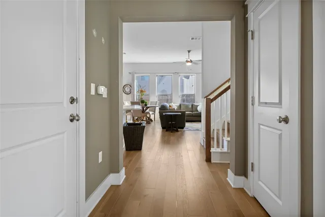 a living room with stainless steel appliances furniture a rug kitchen view and a window