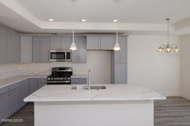 a kitchen with kitchen island a sink appliances and cabinets