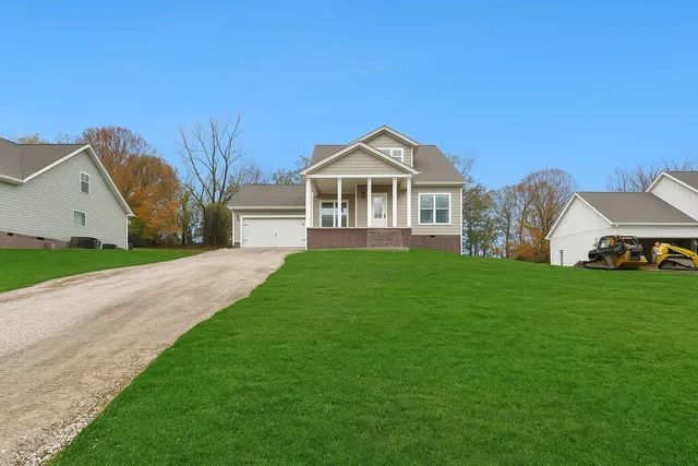 a front view of a house with a yard and trees