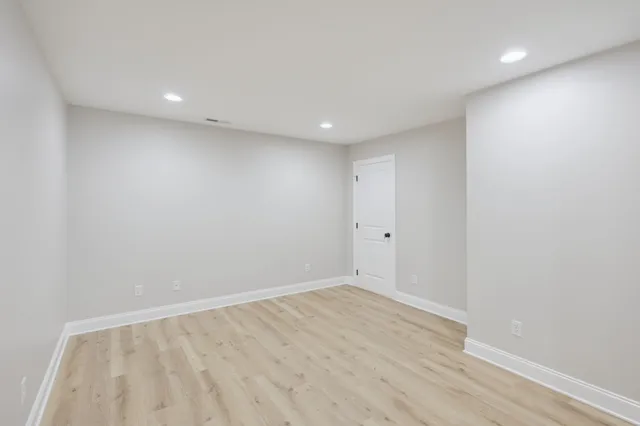 a view of a room with wooden floor and a ceiling fan