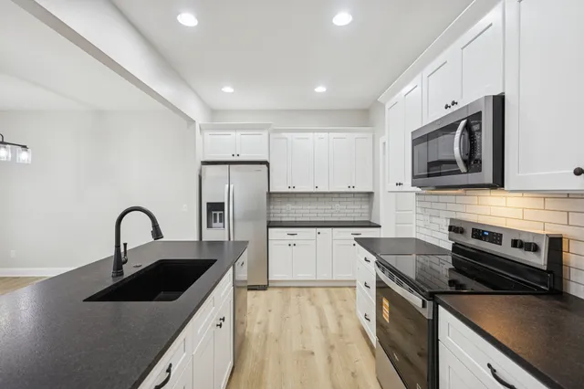 a kitchen with a sink stove and microwave