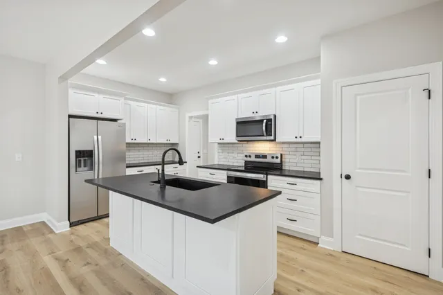 a kitchen with sink a refrigerator and cabinets