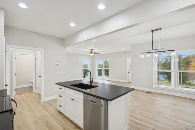 a kitchen with a sink stove and wooden floor