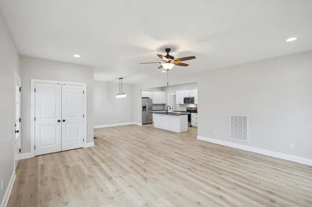a view of an empty room with a kitchen